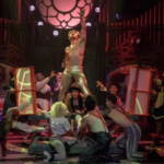 Craig Urbani as Frank-N-Furter with arms raised, surrounded by the cast of The Rocky Horror Show on stage at Montecasino Theatre