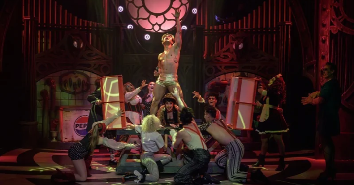 Craig Urbani as Frank-N-Furter with arms raised, surrounded by the cast of The Rocky Horror Show on stage at Montecasino Theatre