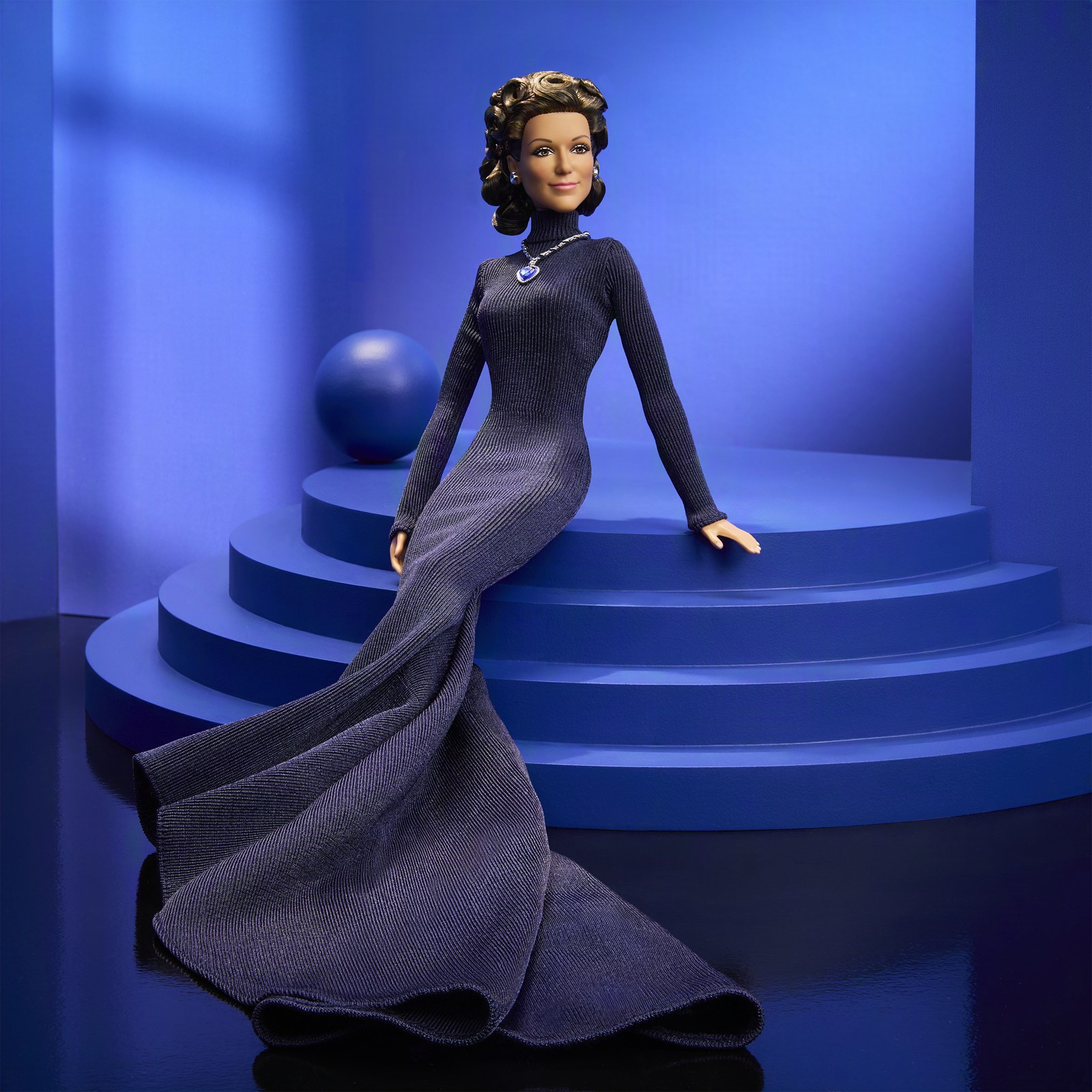 The Celine Dion Barbie doll seated on blue steps